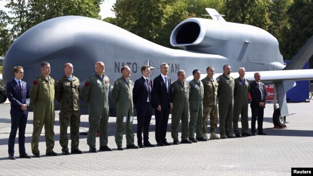 Генсекретар НАТО Єнс Столтенберґ та офіційні особи-учасники саміту позують на тлі безпілотника Північноатлантичного альянсу, Варшава, 8 липня 2016 року
